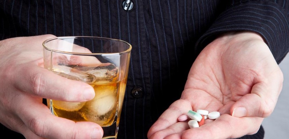 hands-holding-glass-of-whiskey-and-pills1-997x480